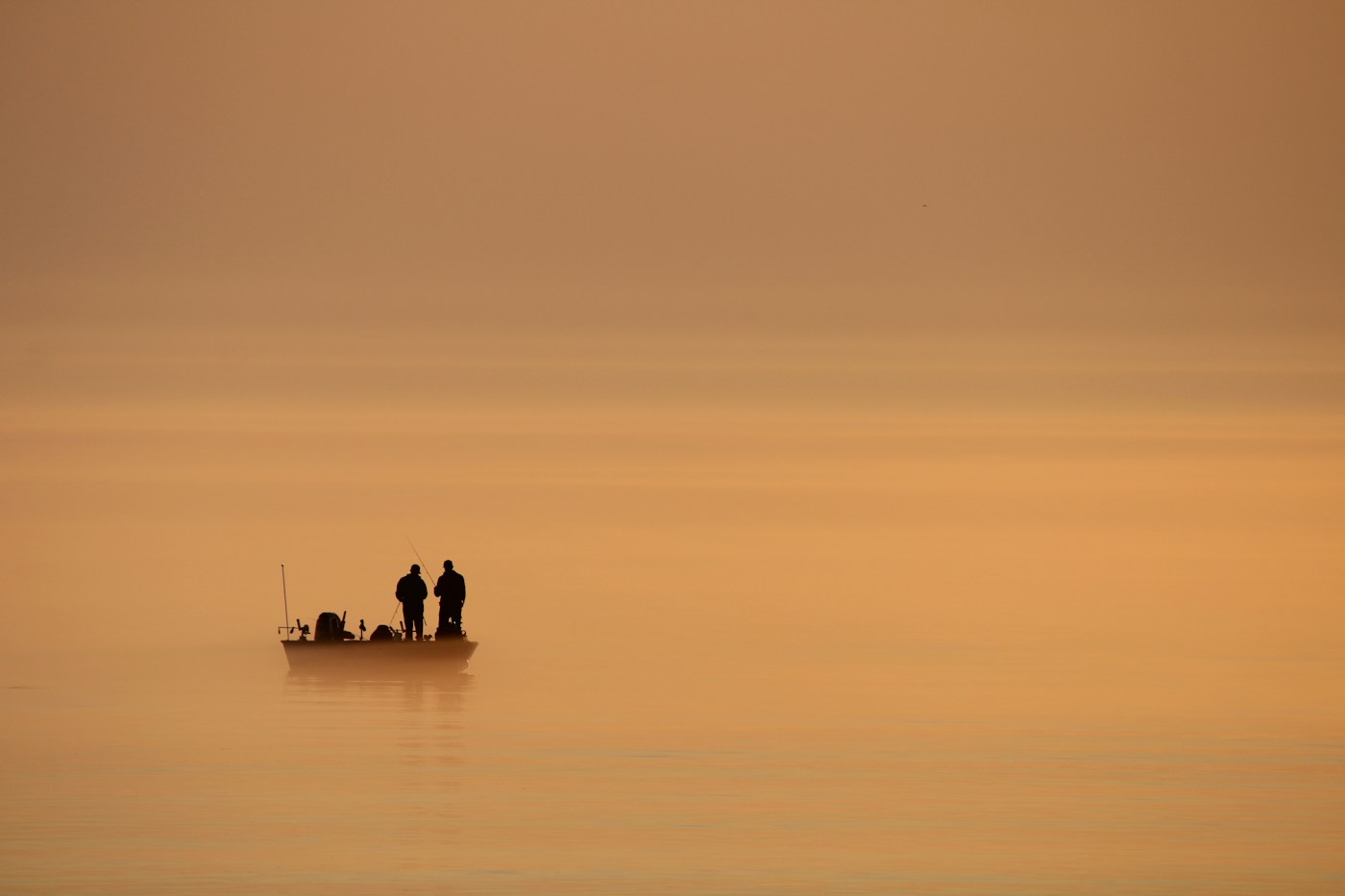 Anglers fishing together from a boat at golden hour