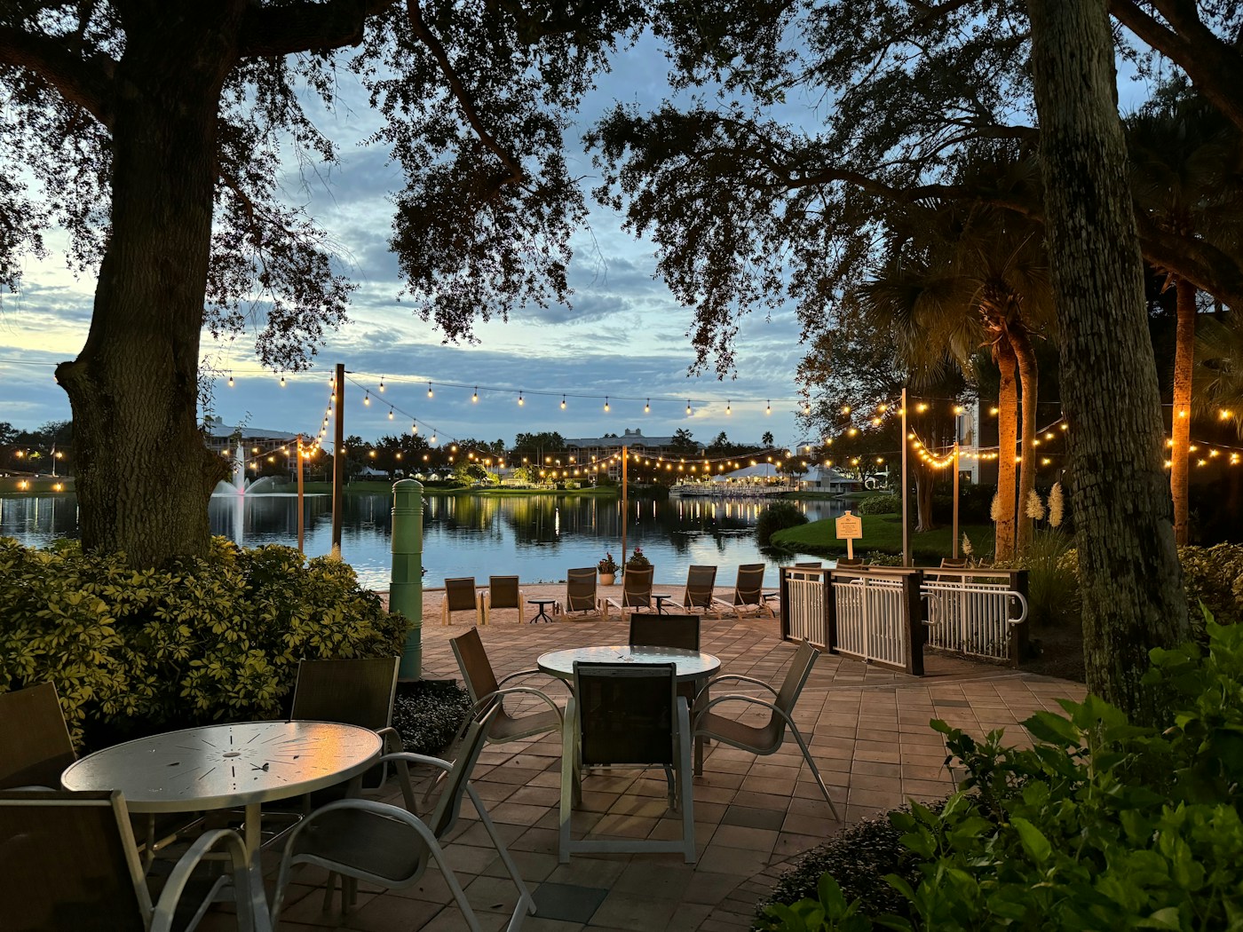 A waterfront patio glowing with string lights beside the lake